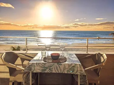 a table on a balcony with a view of the ocean at Apartamento en la playa con garaje in Cádiz