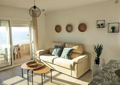 a living room with a couch and a table at Apartamento en la playa con garaje in Cádiz