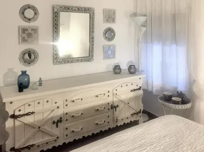 a bedroom with a dresser with a mirror and a bed at Charming House + Chiclana de la Frontera + Garden in Chiclana de la Frontera