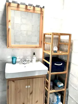 a bathroom with a sink and a mirror and a shelf at Charming House + Chiclana de la Frontera + Garden in Chiclana de la Frontera