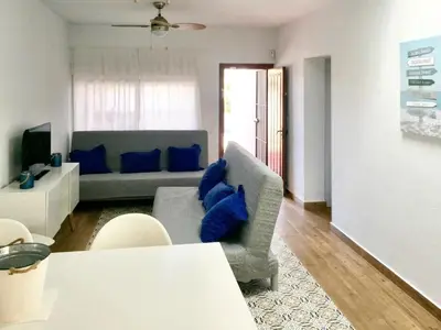 a living room with a gray couch and blue pillows at Charming House + Chiclana de la Frontera + Garden in Chiclana de la Frontera