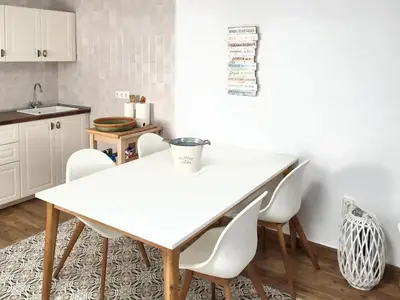 a kitchen with a white table and white chairs at Charming House + Chiclana de la Frontera + Garden in Chiclana de la Frontera