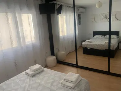 a bedroom with a bed and a large mirror at Duplex a 3 minutos de playa de la victoria Cadiz in Cádiz
