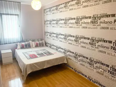 a room with a bed and a wall with writing on it at Duplex a 3 minutos de playa de la victoria Cadiz in Cádiz