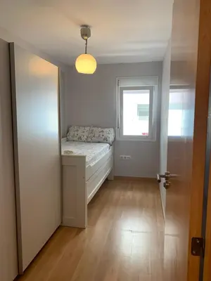 a small bedroom with a bed and a window at Duplex a 3 minutos de playa de la victoria Cadiz in Cádiz