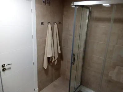 a shower with a glass door and towels in a bathroom at Apartamento Carlos in Rota