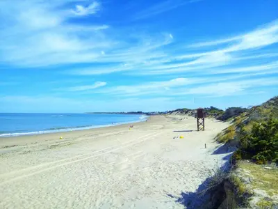 a beach with a person standing on the sand at Apartamento Carlos in Rota