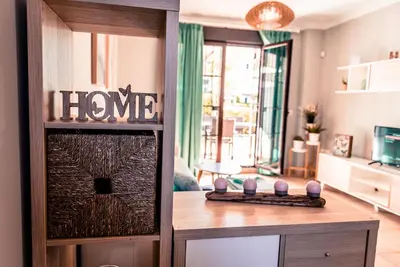 a home living room with a home sign on the door at Apartamentos Coto de San José in Chiclana de la Frontera