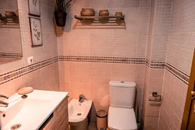 a bathroom with a white toilet and a sink at Apartamentos Coto de San José in Chiclana de la Frontera