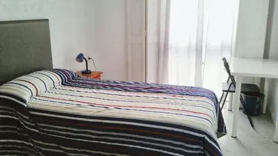 a bed with a striped blanket on it in a room at Spacious apartment in Cádiz 130 m² with balcony and city view in Cádiz