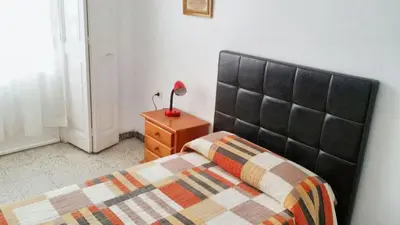 a bedroom with a bed and a lamp on a dresser at Spacious apartment in Cádiz 130 m² with balcony and city view in Cádiz
