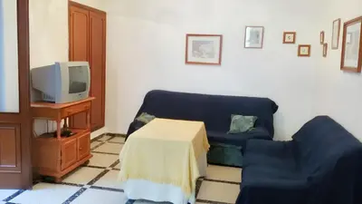 a living room with a blue couch and a tv at Spacious apartment in Cádiz 130 m² with balcony and city view in Cádiz
