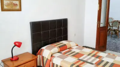 a bedroom with a bed and a red lamp on a table at Spacious apartment in Cádiz 130 m² with balcony and city view in Cádiz