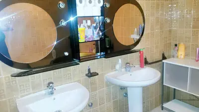 a bathroom with two sinks and two mirrors at Spacious apartment in Cádiz 130 m² with balcony and city view in Cádiz