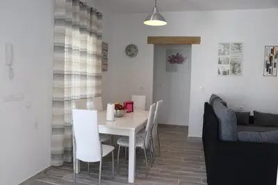 a dining room with a white table and chairs at Chalet carril de los pareja in Conil de la Frontera