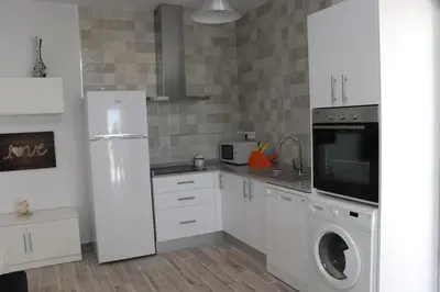 a kitchen with a refrigerator and a washer and dryer at Chalet carril de los pareja in Conil de la Frontera