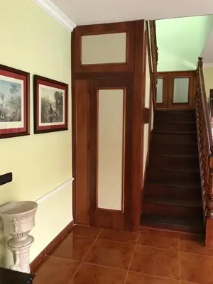 a hallway with a wooden door and stairs at Bahía blanca SM in Cádiz