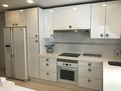 a kitchen with white cabinets and a stainless steel refrigerator at Apartamento Cadiz de Cine in Cádiz