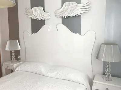 a bedroom with a white bed with wings on the wall at Apartamento Cadiz de Cine in Cádiz