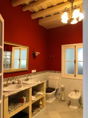 a bathroom with two sinks and a toilet at Lujosa suite privada en casa del S XIX in Sanlúcar de Barrameda