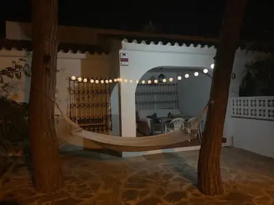 a hammock in a room with trees and lights at Chalet adosado playa de La Barrosa in Chiclana de la Frontera