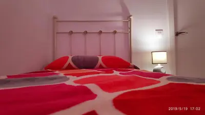 a bedroom with a red and white bed with a lamp at Loft 500 metros de la playa in Cádiz
