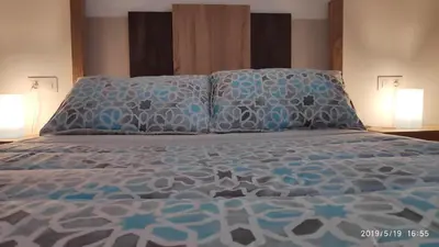 a bed with blue and white sheets and pillows at Loft 500 metros de la playa in Cádiz