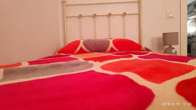 a bed with a red and white blanket on it at Loft 500 metros de la playa in Cádiz