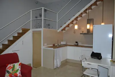 a kitchen with a staircase and a table and chairs at Duplex Daises in San Fernando