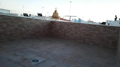 a brick wall with a tile floor next to a building at Duplex Daises in San Fernando