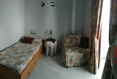 a bedroom with a bed and a chair at Duplex Daises in San Fernando