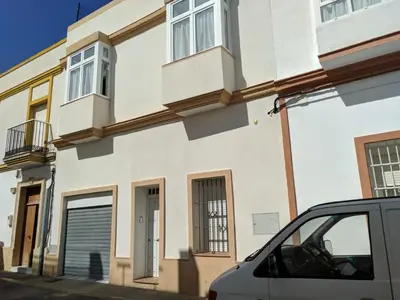 a white building with a car parked in front of it at Duplex Daises in San Fernando