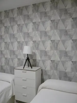 a bedroom with two beds and a table with a lamp at Real Escuela Home in Jerez de la Frontera