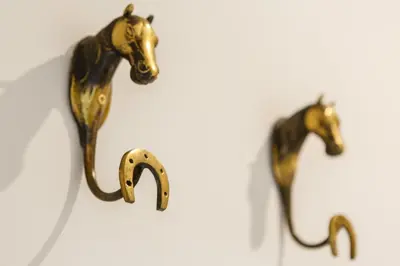 a couple of bronze horses on a wall at Real Escuela Home in Jerez de la Frontera
