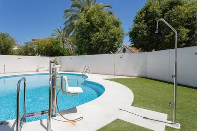 a swimming pool in a backyard with a fence at Real Escuela Home in Jerez de la Frontera