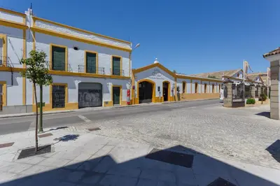 an empty street in a small town with buildings at Real Escuela Home in Jerez de la Frontera