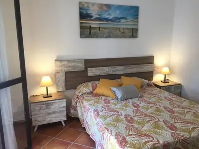 a bedroom with a bed and two lamps on tables at Casa Ananda y Casa Rengue in Conil de la Frontera