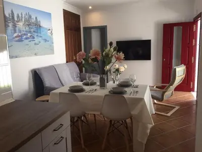 a living room with a table with a vase of flowers on it at Casa Ananda y Casa Rengue in Conil de la Frontera