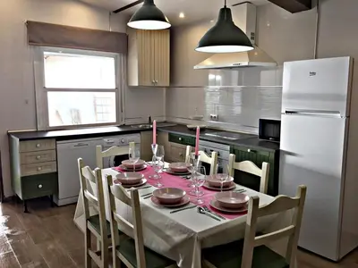 a kitchen with a table with chairs and a white refrigerator at Casa Ananda y Casa Rengue in Conil de la Frontera