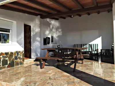 a patio with a wooden table and a bench at Casa Ananda y Casa Rengue in Conil de la Frontera