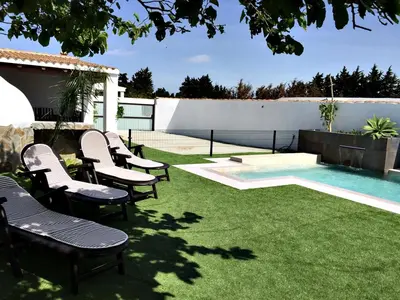 a group of chairs sitting next to a swimming pool at Casa Ananda y Casa Rengue in Conil de la Frontera