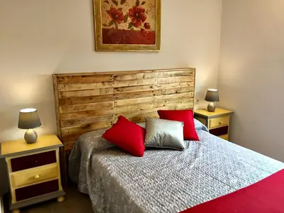 a bedroom with a bed with red pillows on it at Casa Ananda y Casa Rengue in Conil de la Frontera
