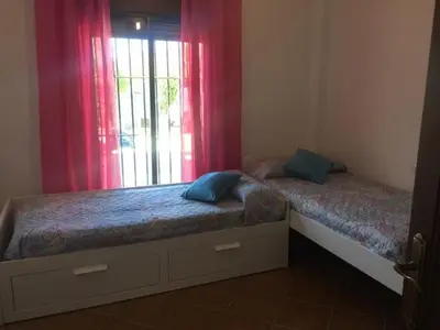 a bedroom with two twin beds and a window at Casa Ananda y Casa Rengue in Conil de la Frontera