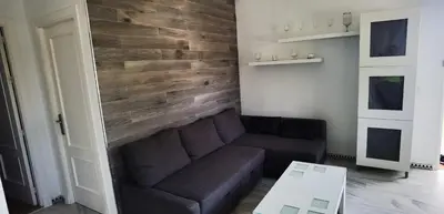 a living room with a couch and a wooden wall at LA BARROSA-NOVO SANCTI PETRI, wifi, aire acondicionado, parking in Chiclana de la Frontera