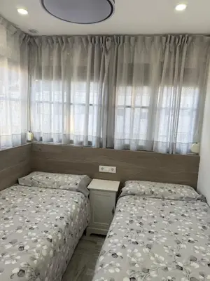 a bedroom with two beds and a window at LA BARROSA-NOVO SANCTI PETRI, wifi, aire acondicionado, parking in Chiclana de la Frontera