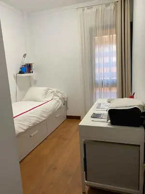 a bedroom with a bed and a desk and a window at apartamento Jacaranda centro in El Puerto de Santa María
