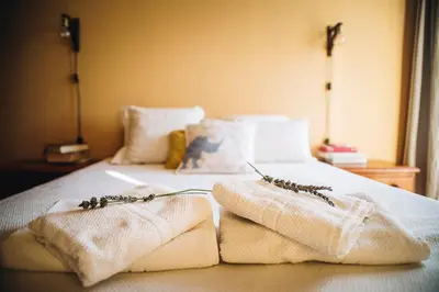 a bed with towels and dried flowers on it at apartamento Jacaranda centro in El Puerto de Santa María