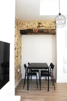 a dining room with a black table and chairs at Plaza de España building in Cádiz