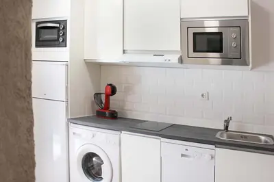 a kitchen with a washing machine and a microwave at Plaza de España building in Cádiz