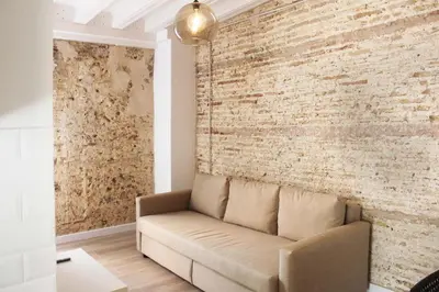 a living room with a couch against a brick wall at Plaza de España building in Cádiz